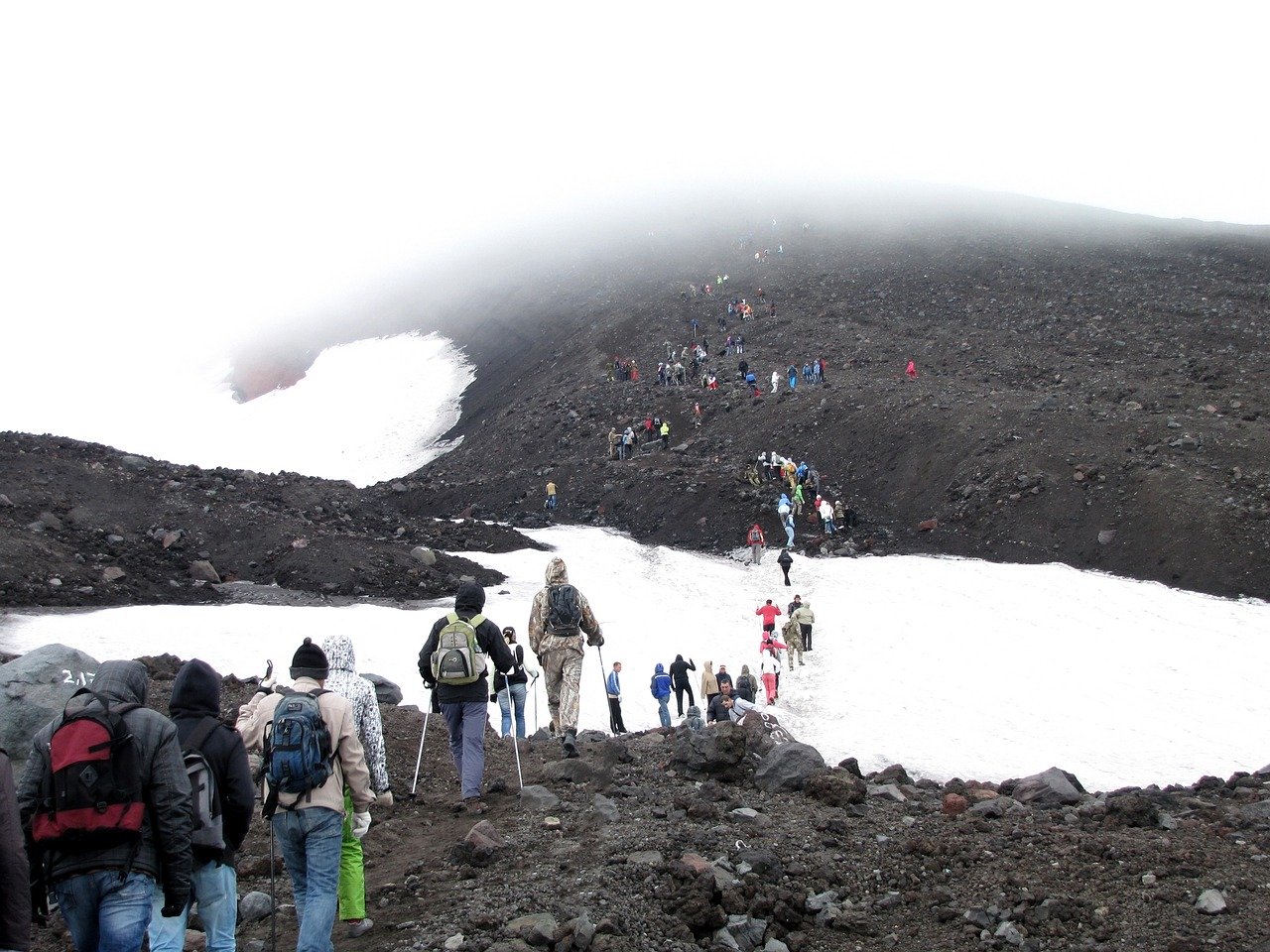 A group of people standing on top of a snow covered mountain Description automatically generated