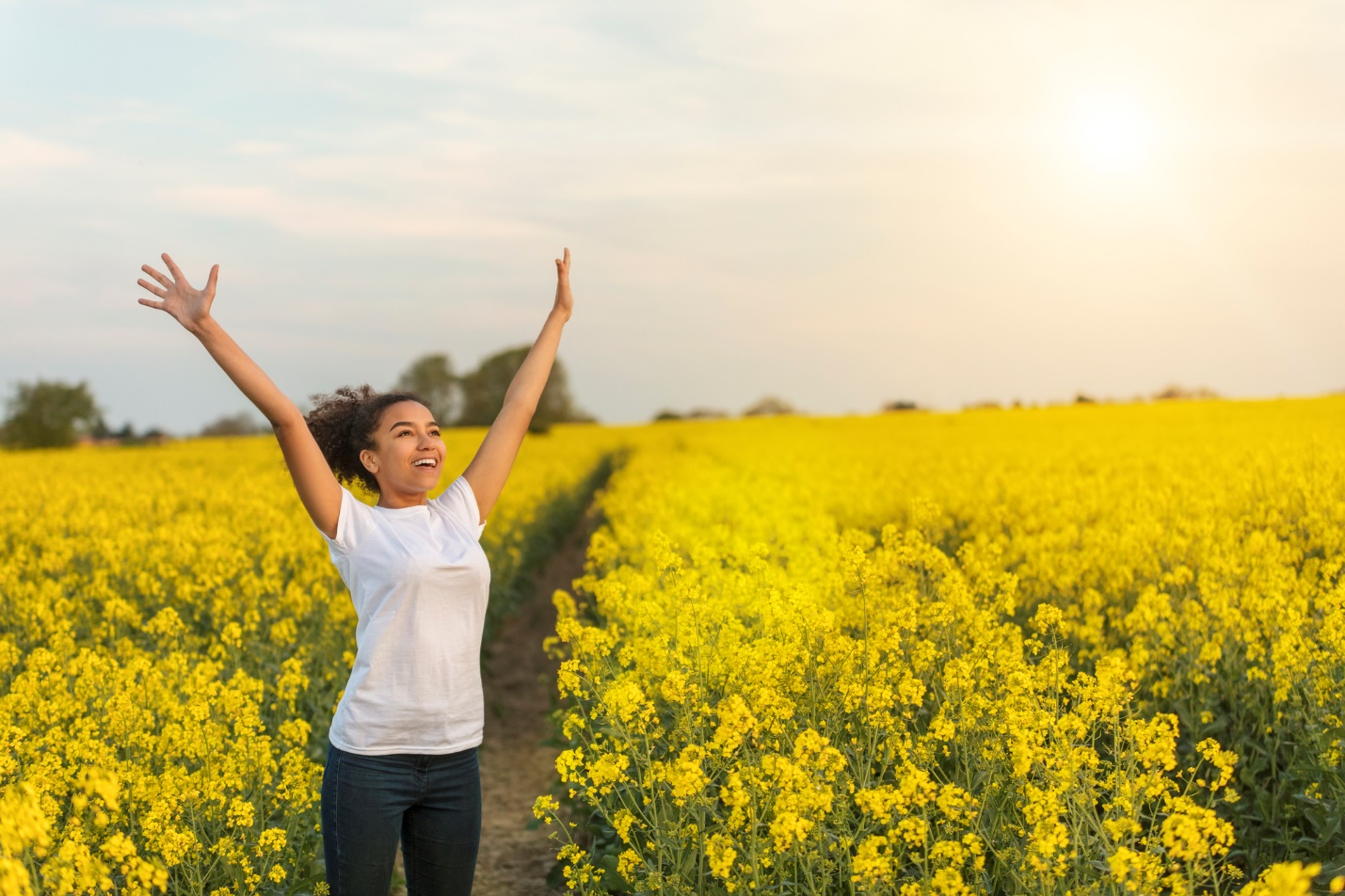 A person standing in a field of yellow flowers with his arms raised

Description automatically generated with medium confidence