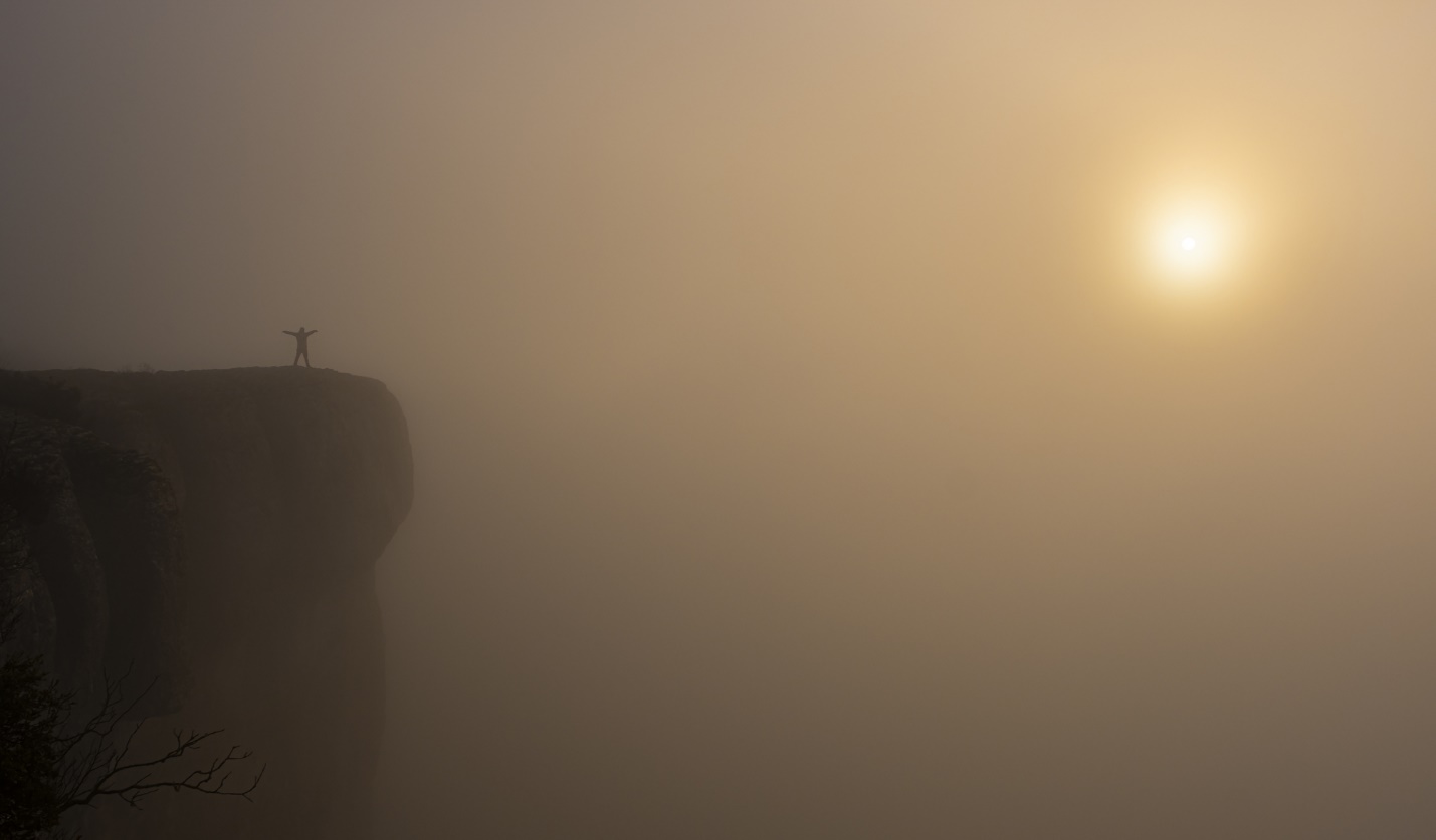 A foggy landscape with a cross on top of a hill

Description automatically generated with low confidence
