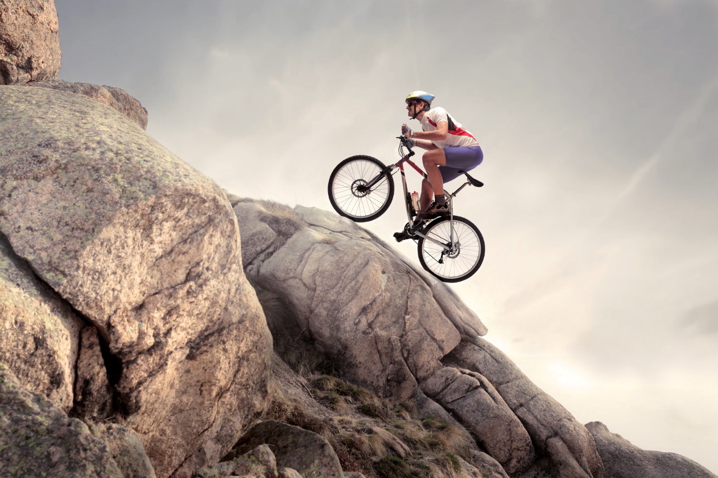 A person riding a bike on a rock

Description automatically generated with medium confidence