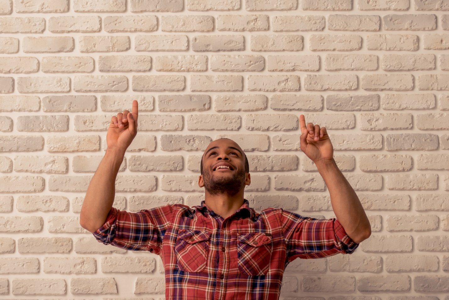 A person sitting in front of a brick wall with his hands up

Description automatically generated with medium confidence