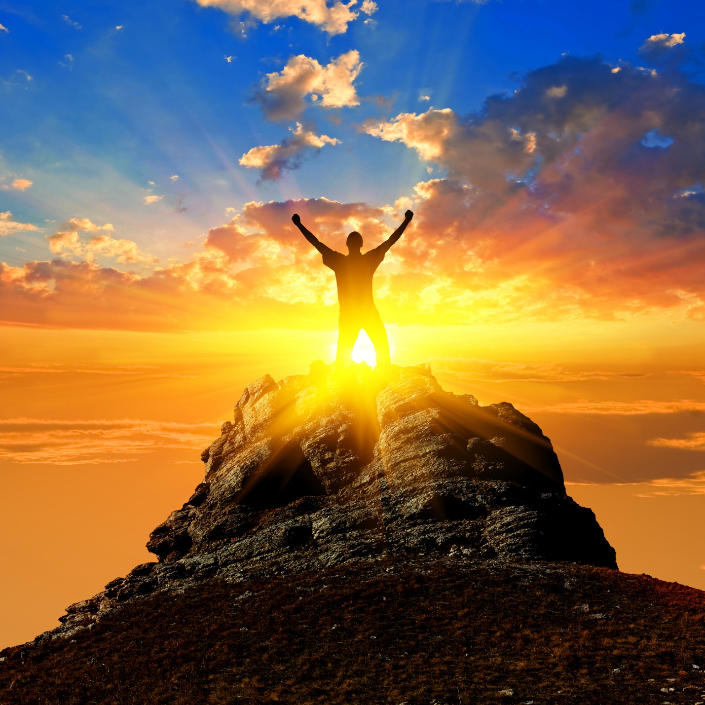 A person standing on a rock with the sun behind them

Description automatically generated with low confidence