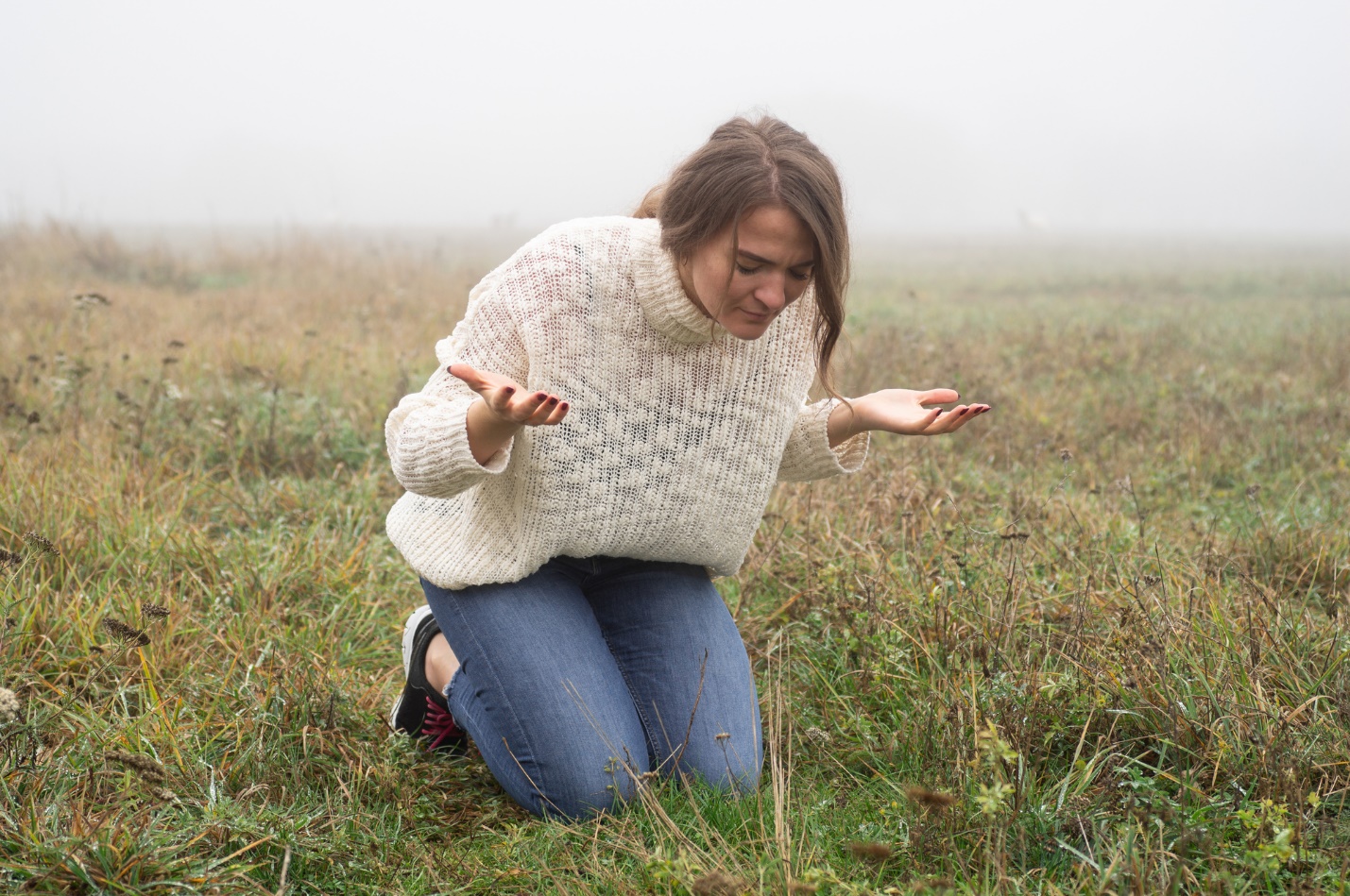 A person kneeling in grass with her hands up

Description automatically generated with low confidence