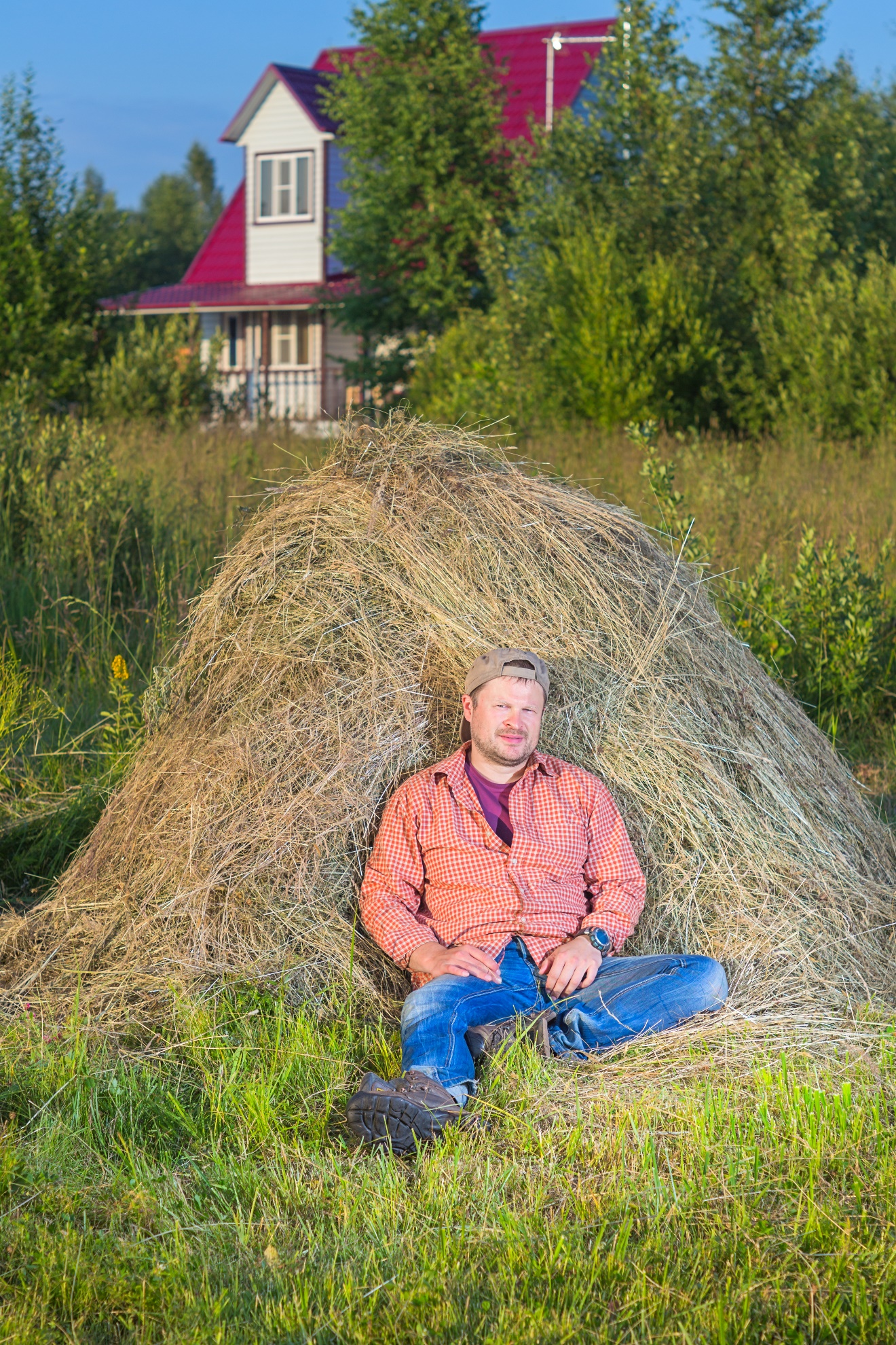 A person sitting on a pile of hay

Description automatically generated with medium confidence