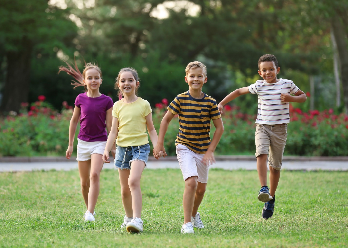 A group of children running on grass

Description automatically generated