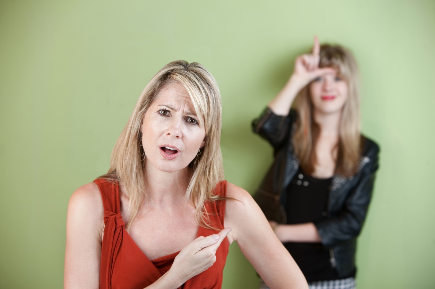 A person pointing her finger to her forehead

Description automatically generated