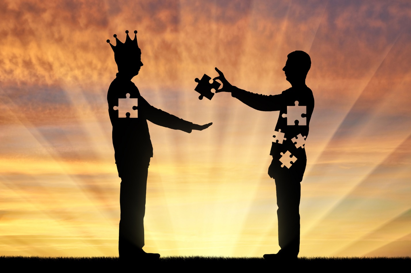 A silhouette of two men with a crown and puzzle pieces

Description automatically generated