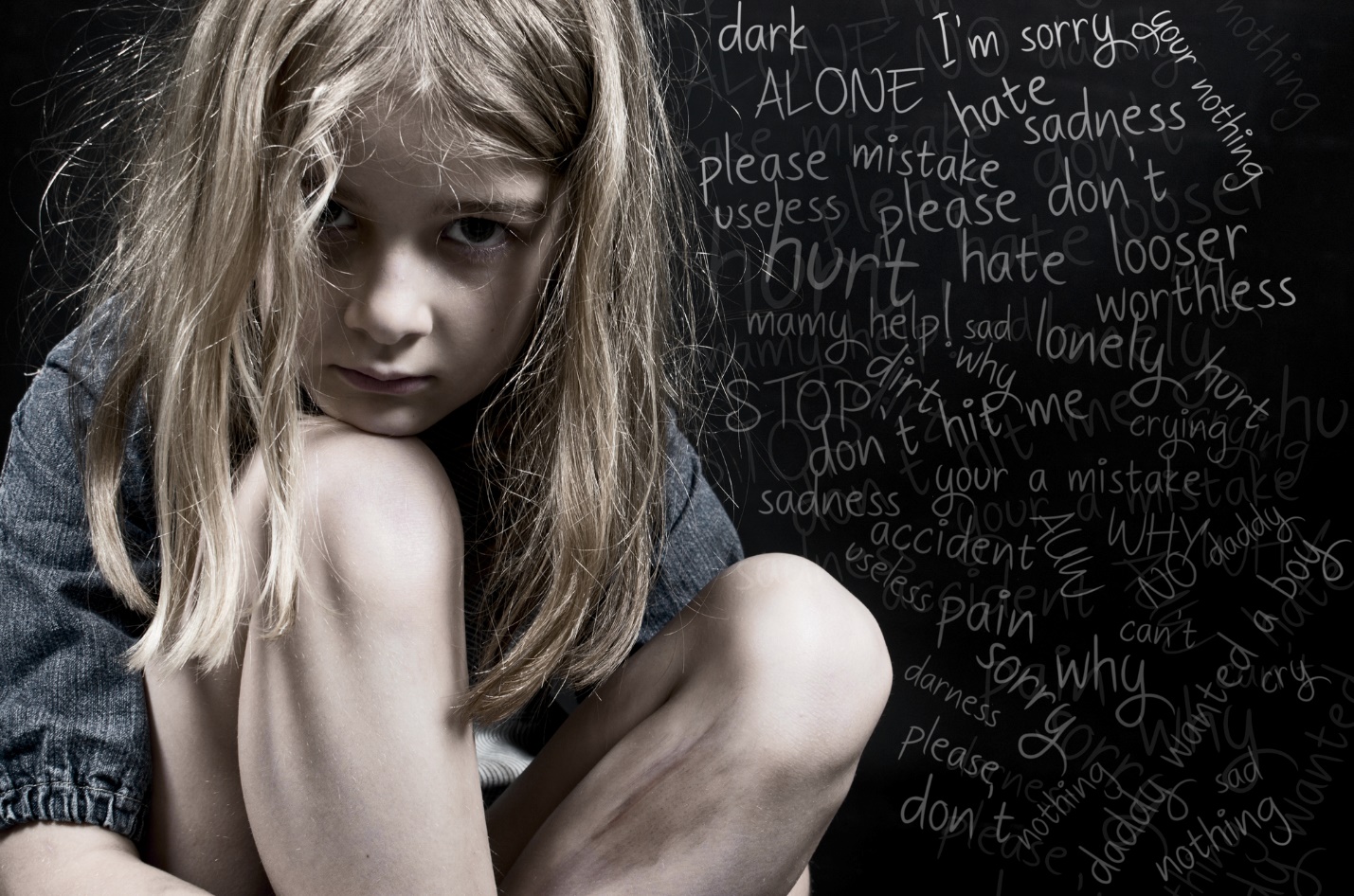 A young child sitting in front of a chalkboard

Description automatically generated