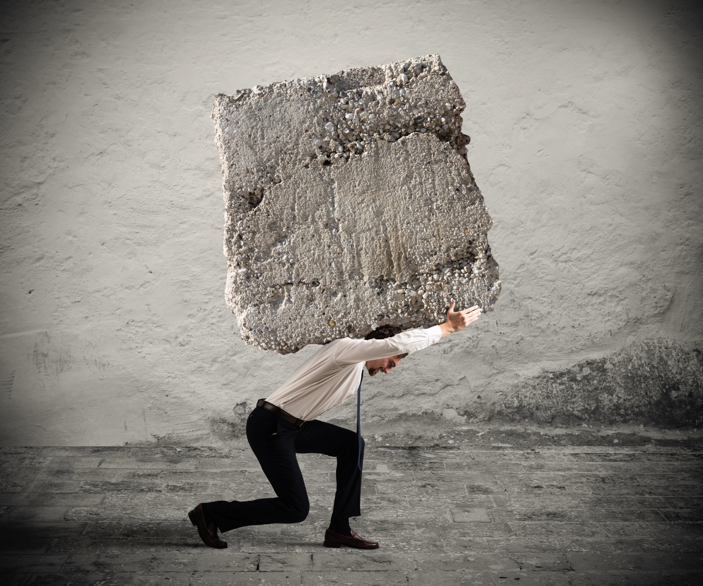 A person carrying a large stone on his back

Description automatically generated