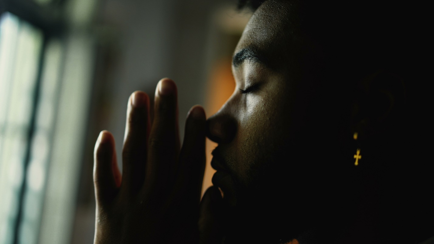 A close-up of a person praying

Description automatically generated