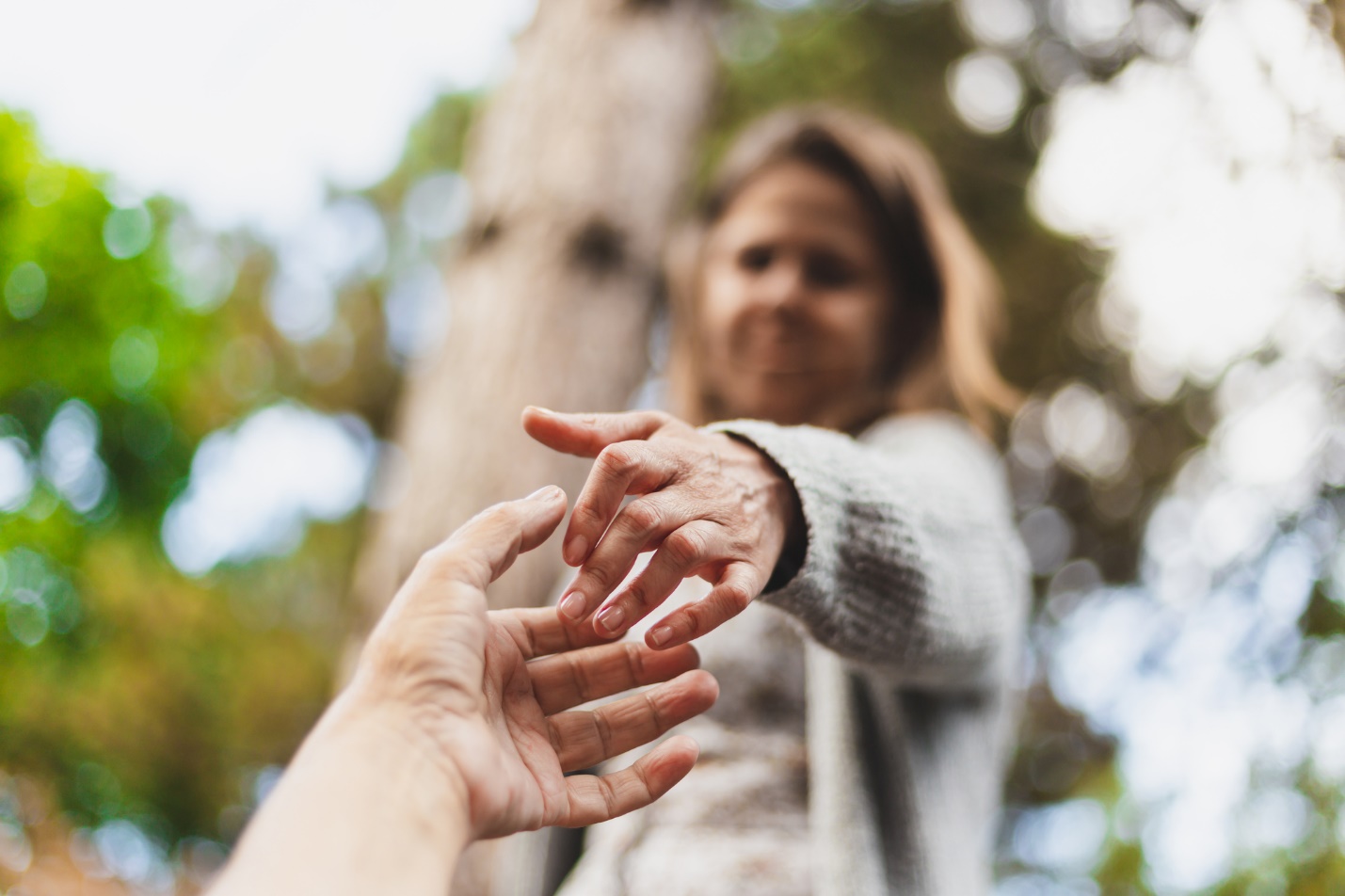 A person reaching out to reach for a person

Description automatically generated