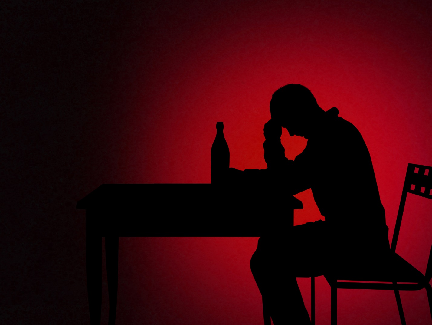 A silhouette of a person sitting at a table

Description automatically generated