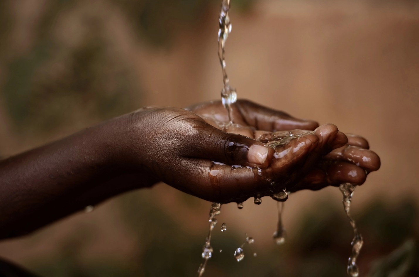 Close-up of a person's hands pouring water

Description automatically generated