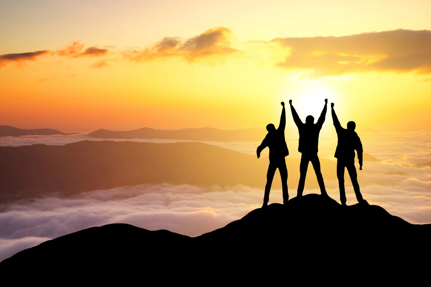 A group of people standing on a mountain with their hands up

Description automatically generated