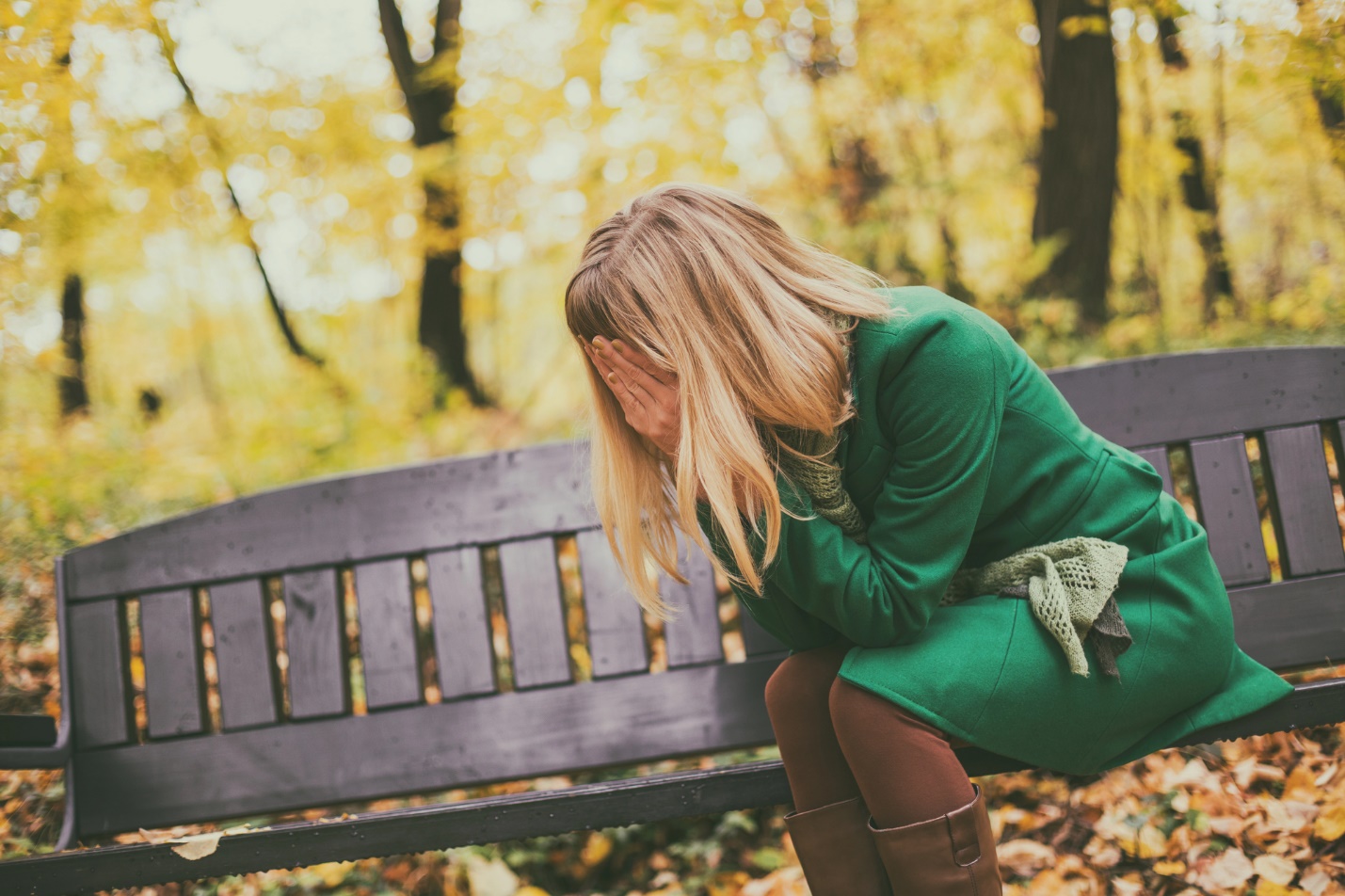 A person kneeling on a bench

Description automatically generated