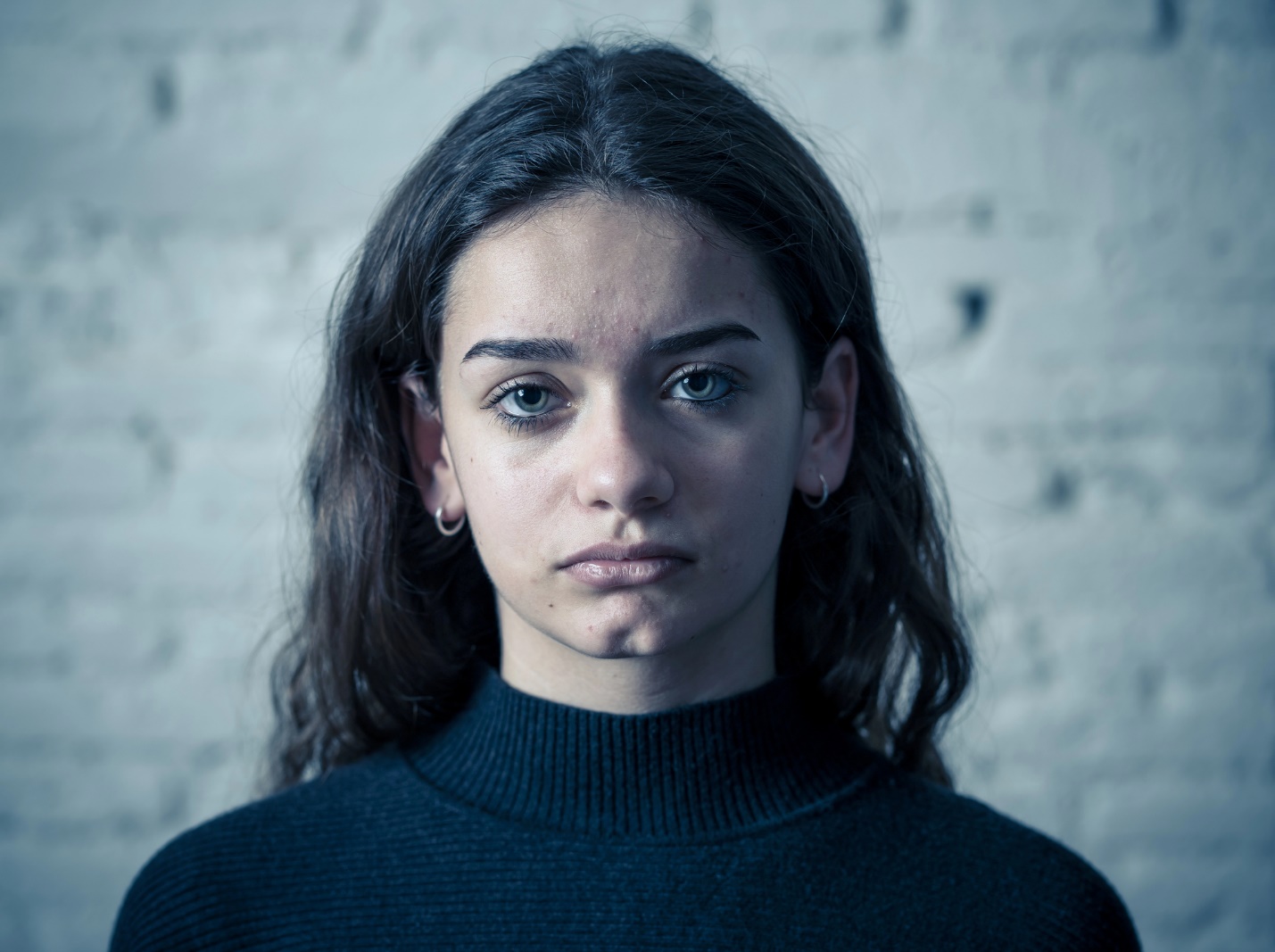 A person with long hair wearing a black turtleneck

Description automatically generated