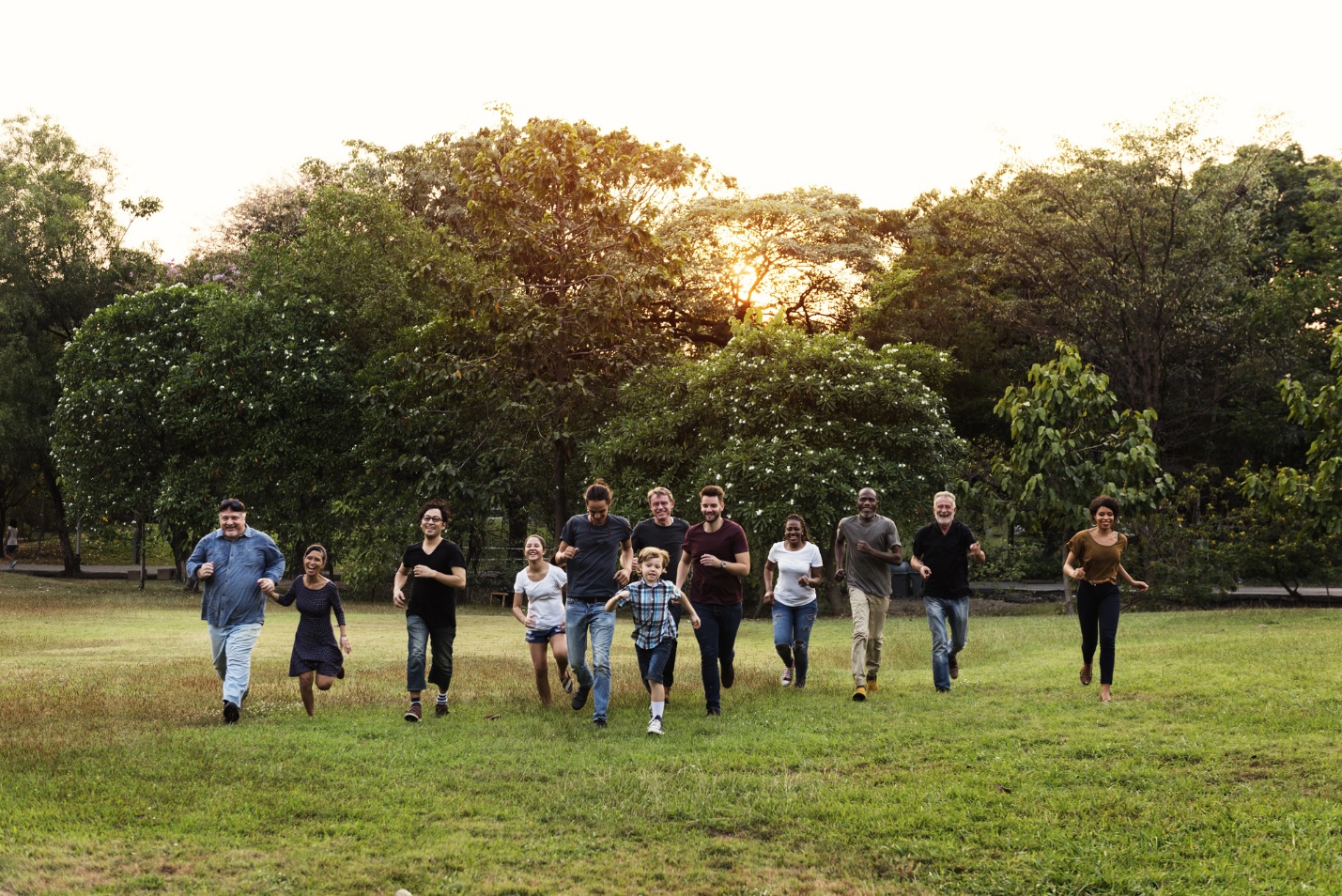 A group of people running on grass

Description automatically generated