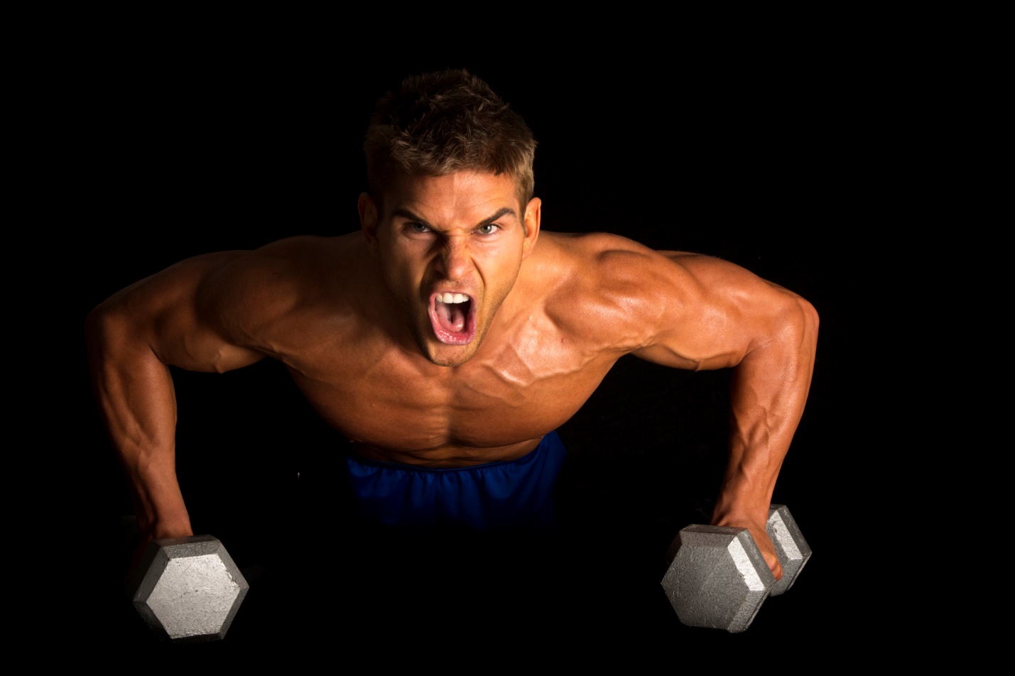 A person lifting weights with his mouth open

Description automatically generated