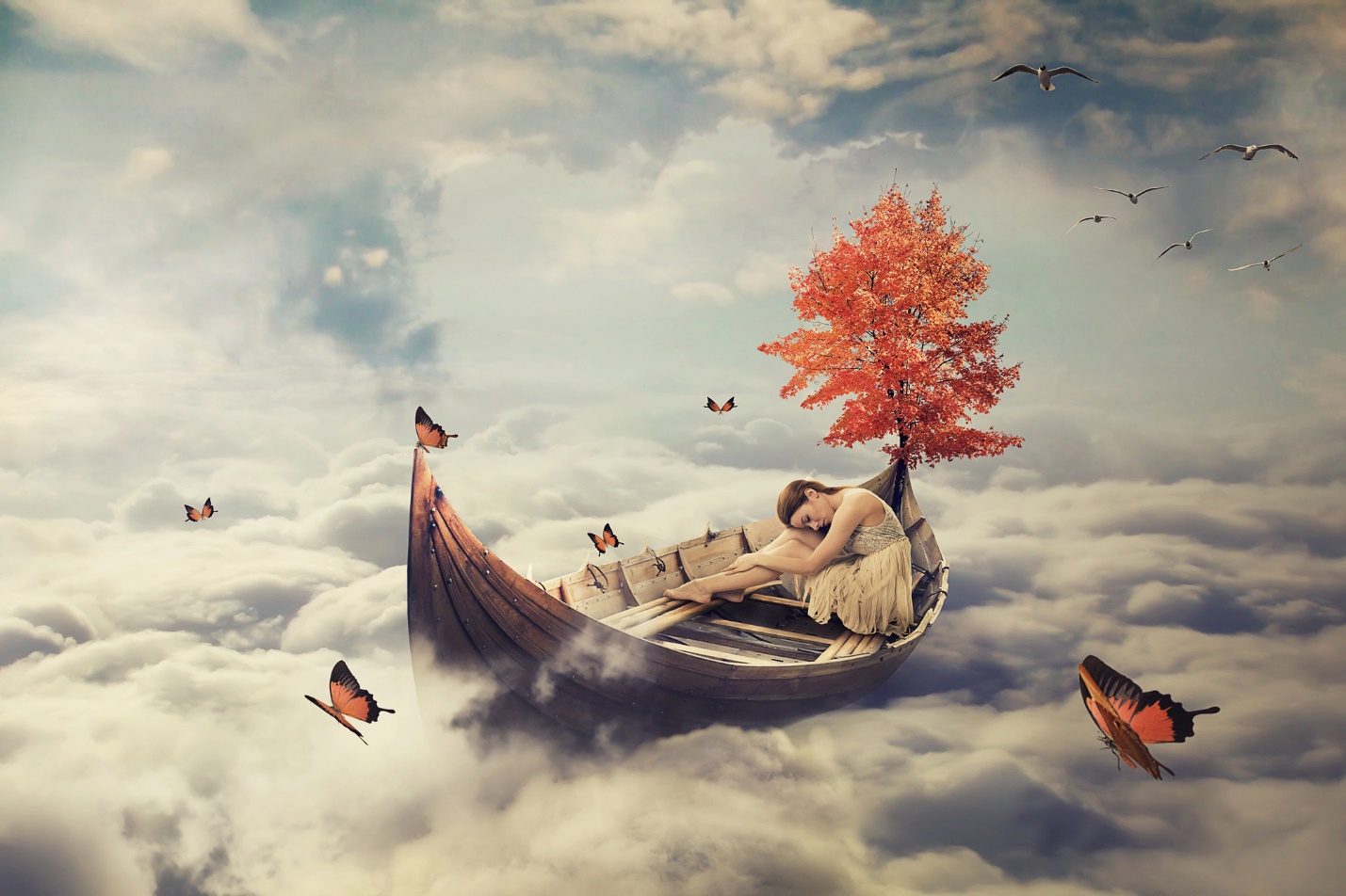 A person lying in a boat in the clouds

Description automatically generated